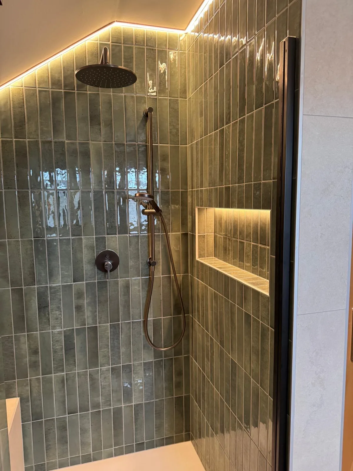 Begehbare Dusche mit grünen Stabfliesen, Regendusche und beleuchteter Ablagenische